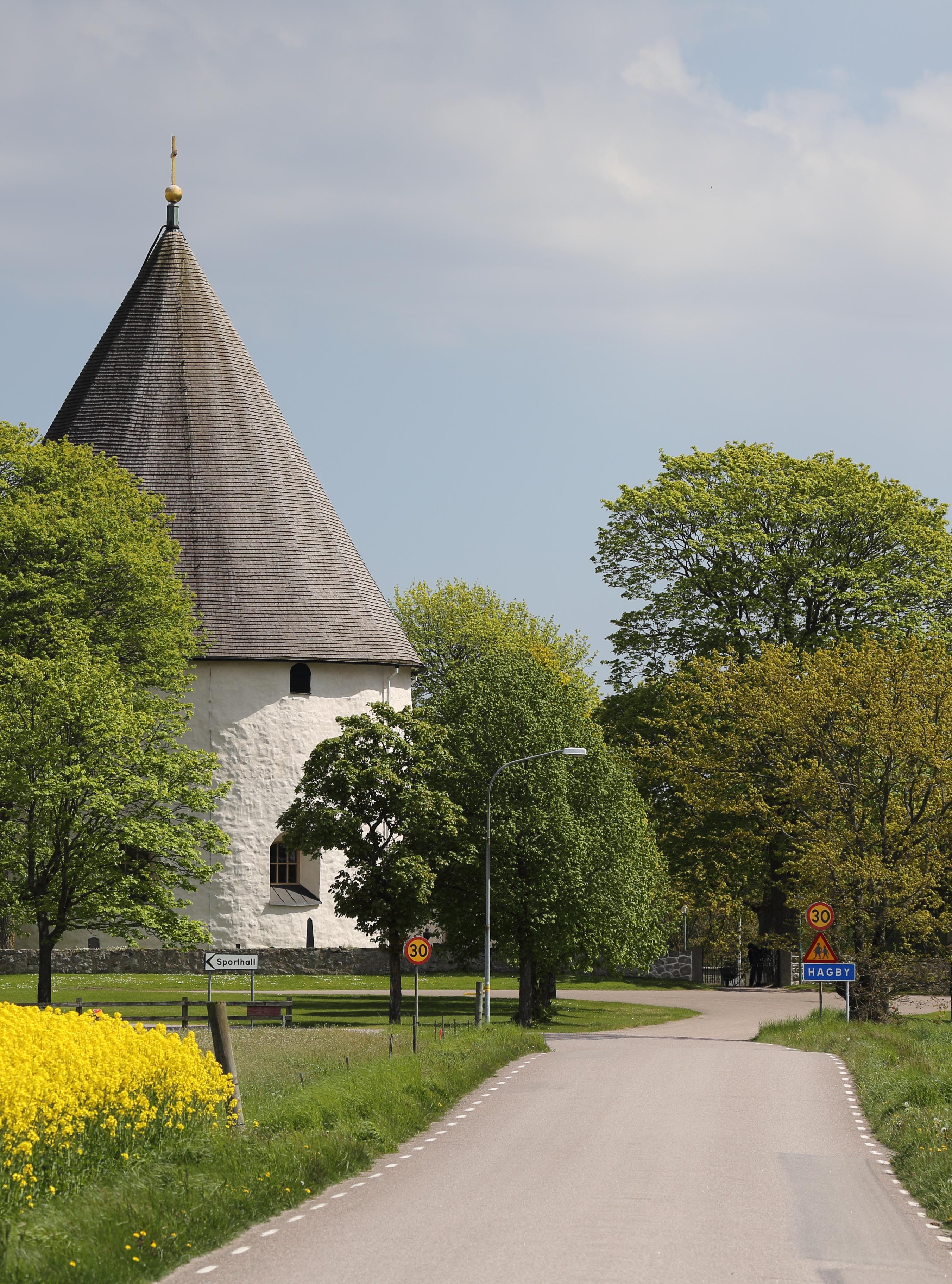 Kyrka vid landsväg omringad av gula fält.