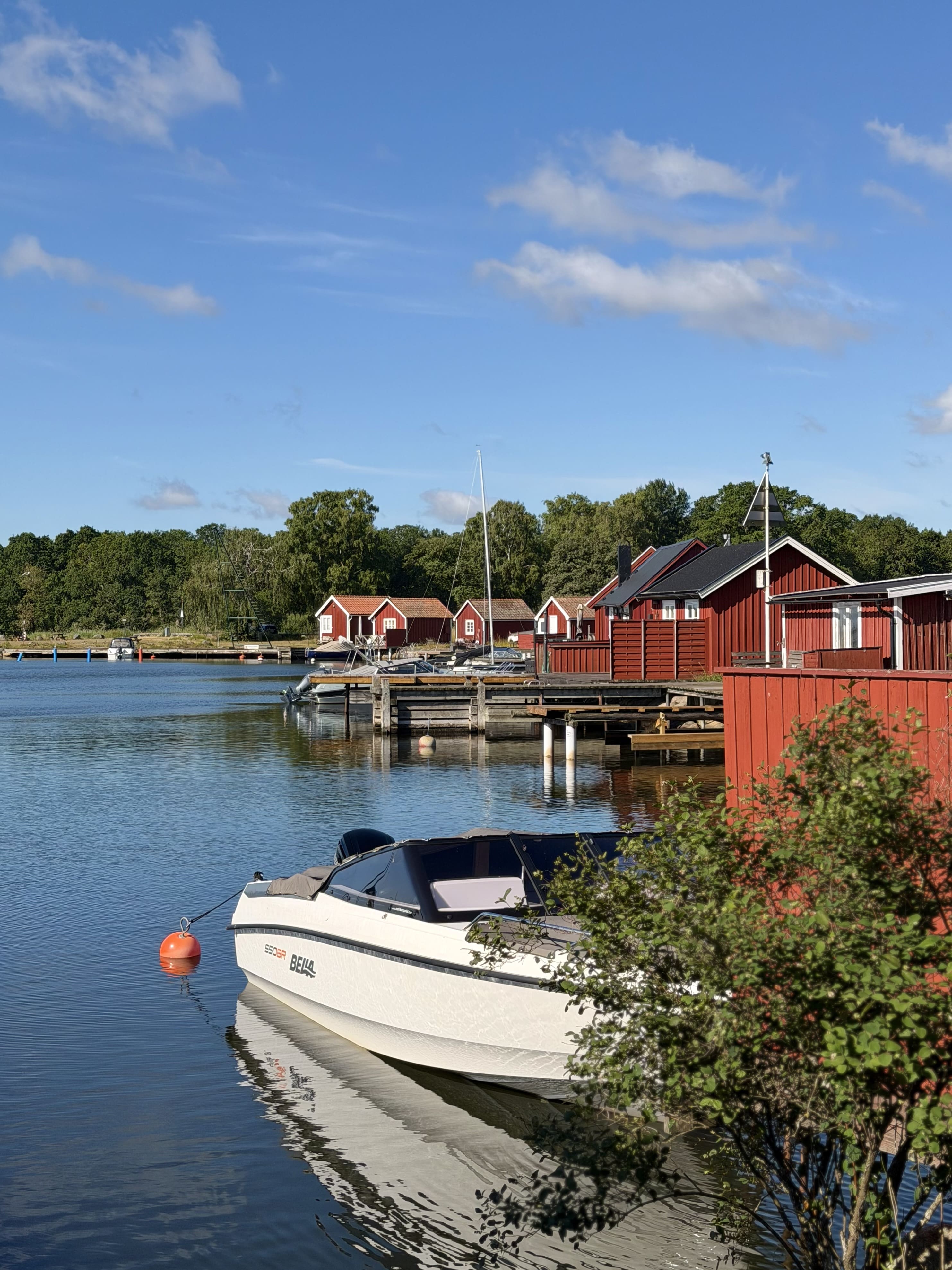 Röda fiskestugor vid vattnet.