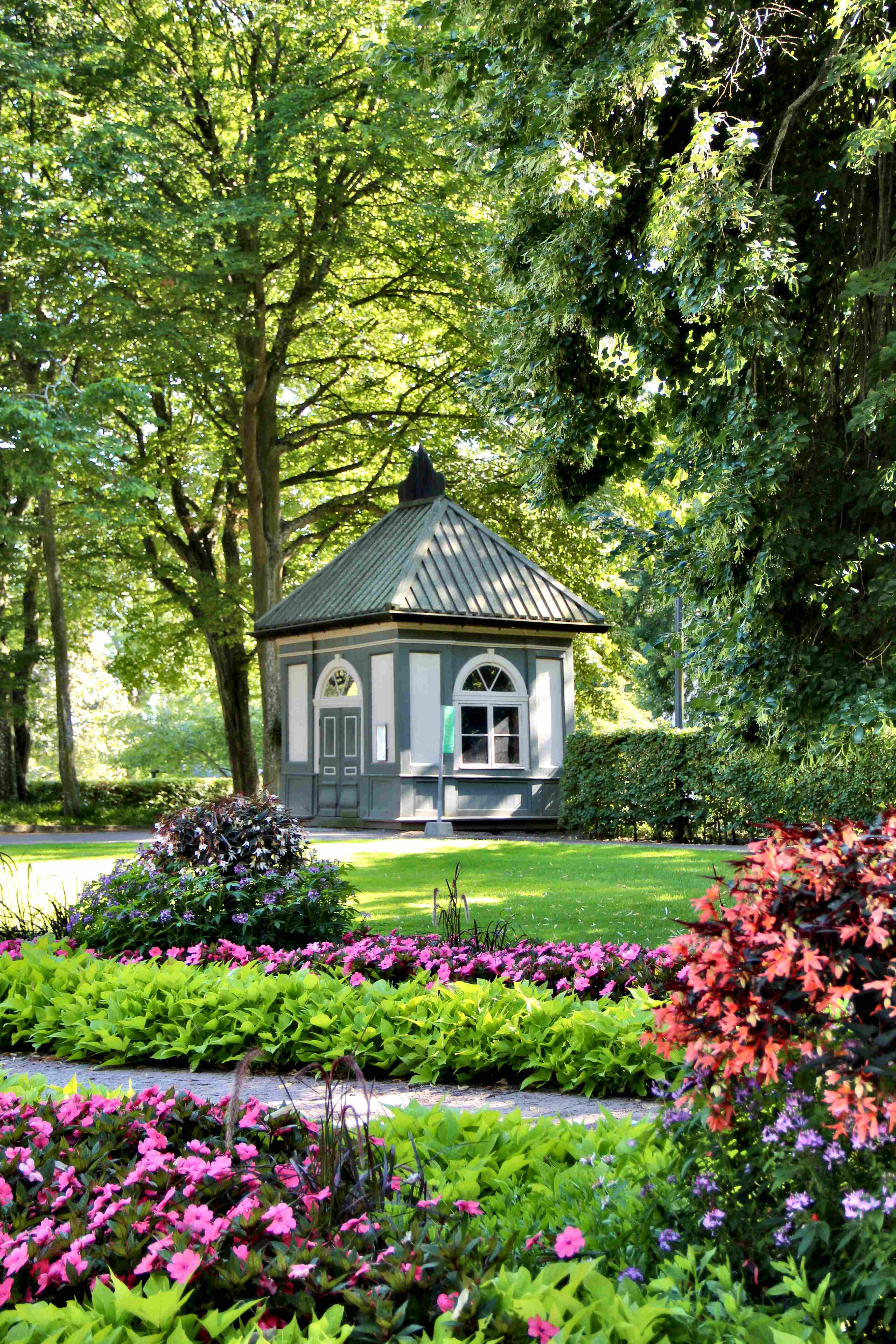 Lusthus i stadsparken omringat av grönska.