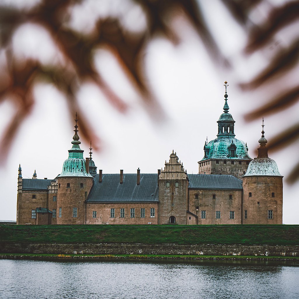 Kalmar Slott. I förgrunden ramas slottet in av höstfärgade löv.