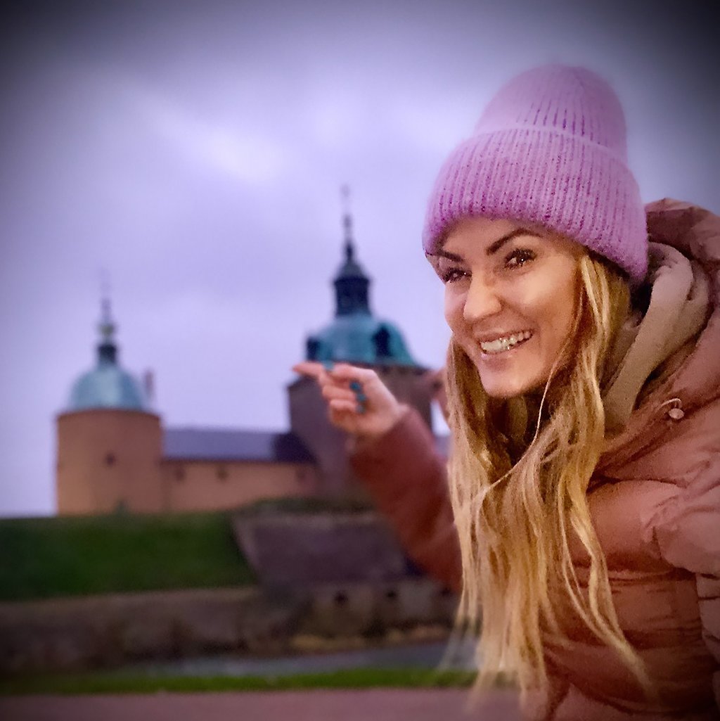 Marika Axén står framför slottet och pekar mot det.