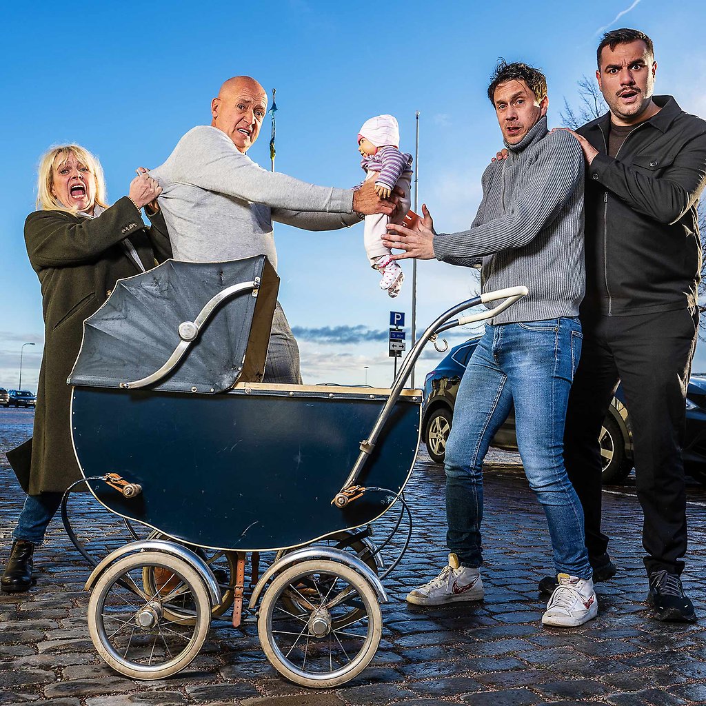 På rad står Sussie Eriksson, Thomas Petersson, Ola Forssmed och Edward af Sillén. Mellan sig håller de en docka och framför står en gammaldags barnvagn.