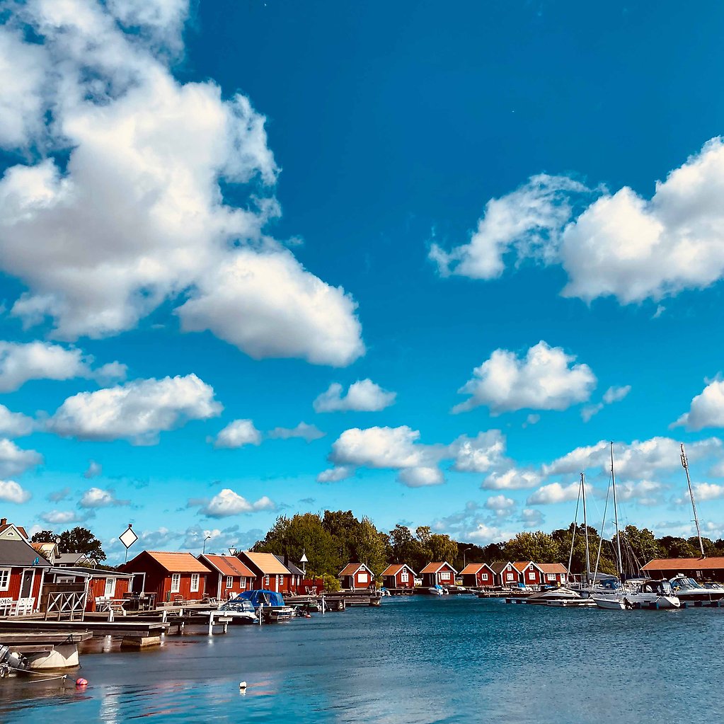 Fiskestugor mot en blå himmel med vita moln
